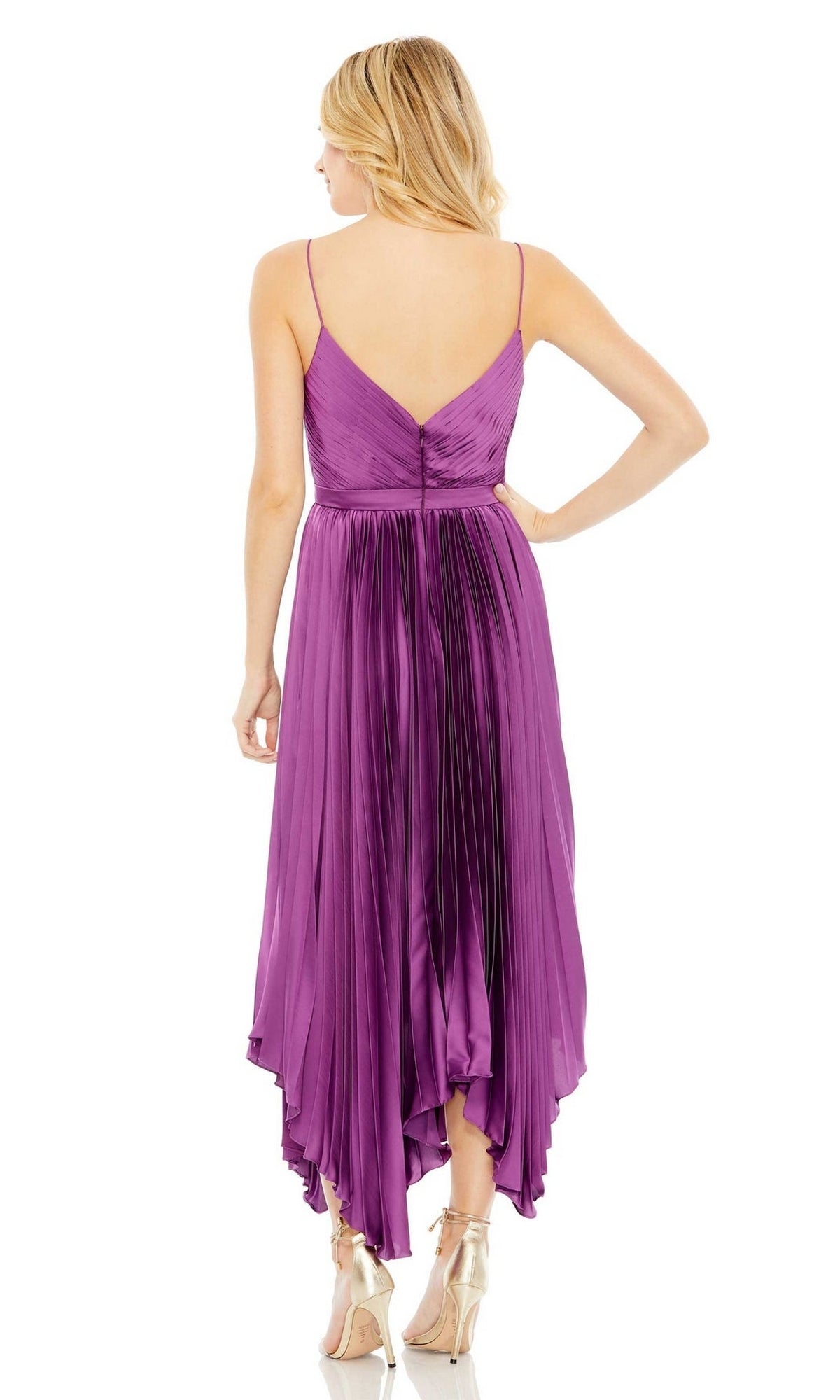 A blonde woman models the Mac Duggal 49637 short purple wedding guest dress with pleats and no sleeves, paired with beige heels, shown from the back against a white background.